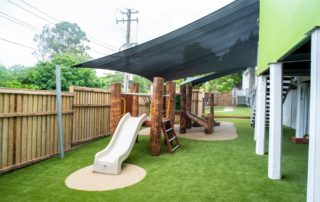 Log fort with slide and climbing wall on wet pour & AstroTurf