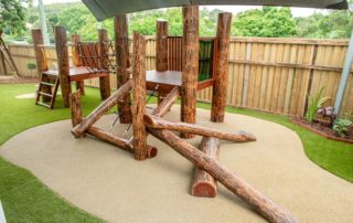 Log fort with slide and climbing wall on rubber mat & astro