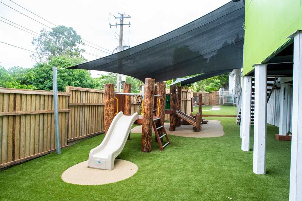 Log fort with slide and climbing wall on wet pour & AstroTurf
